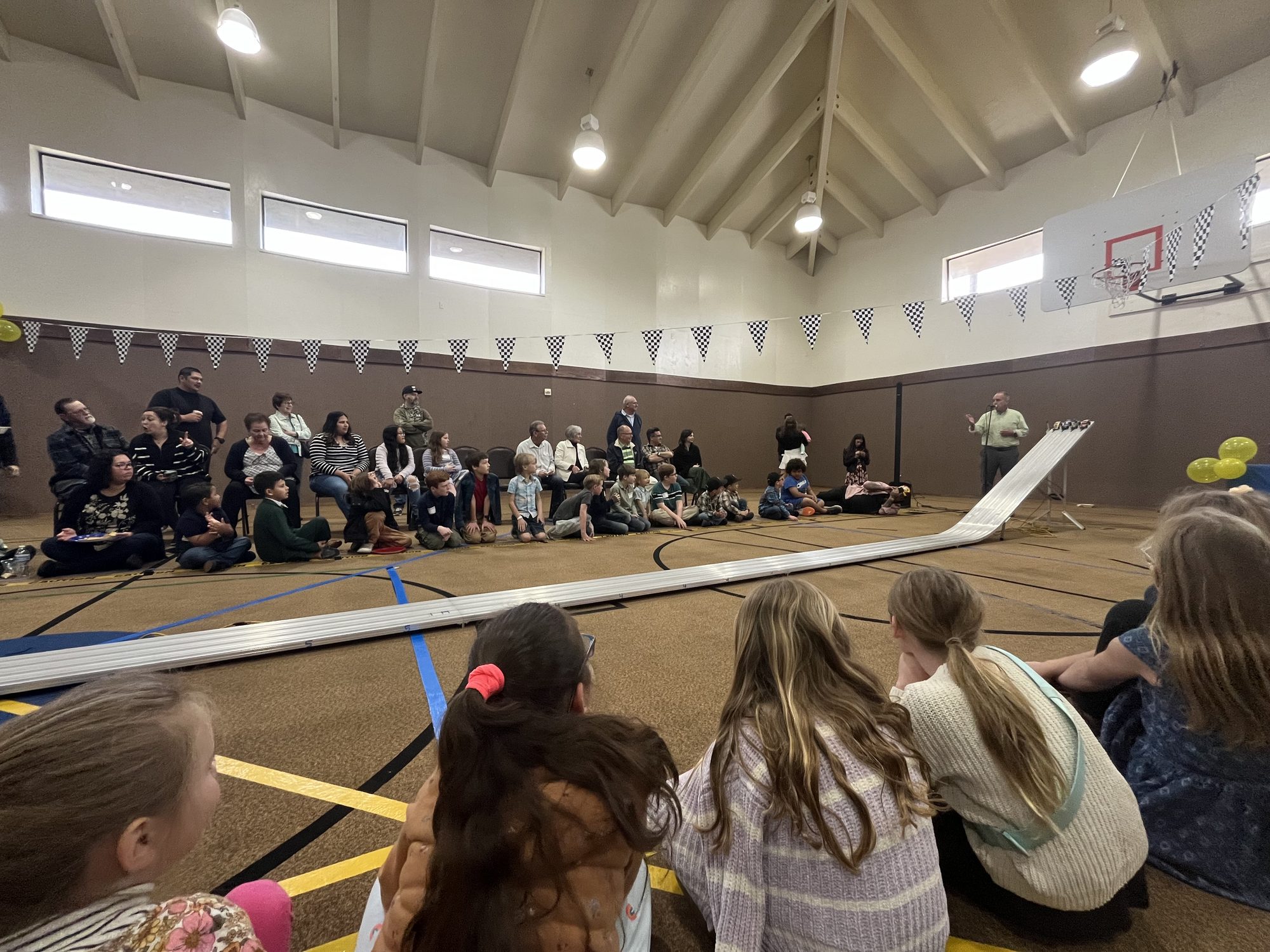 Families watching the AWANA pinewood derby race in the church gym