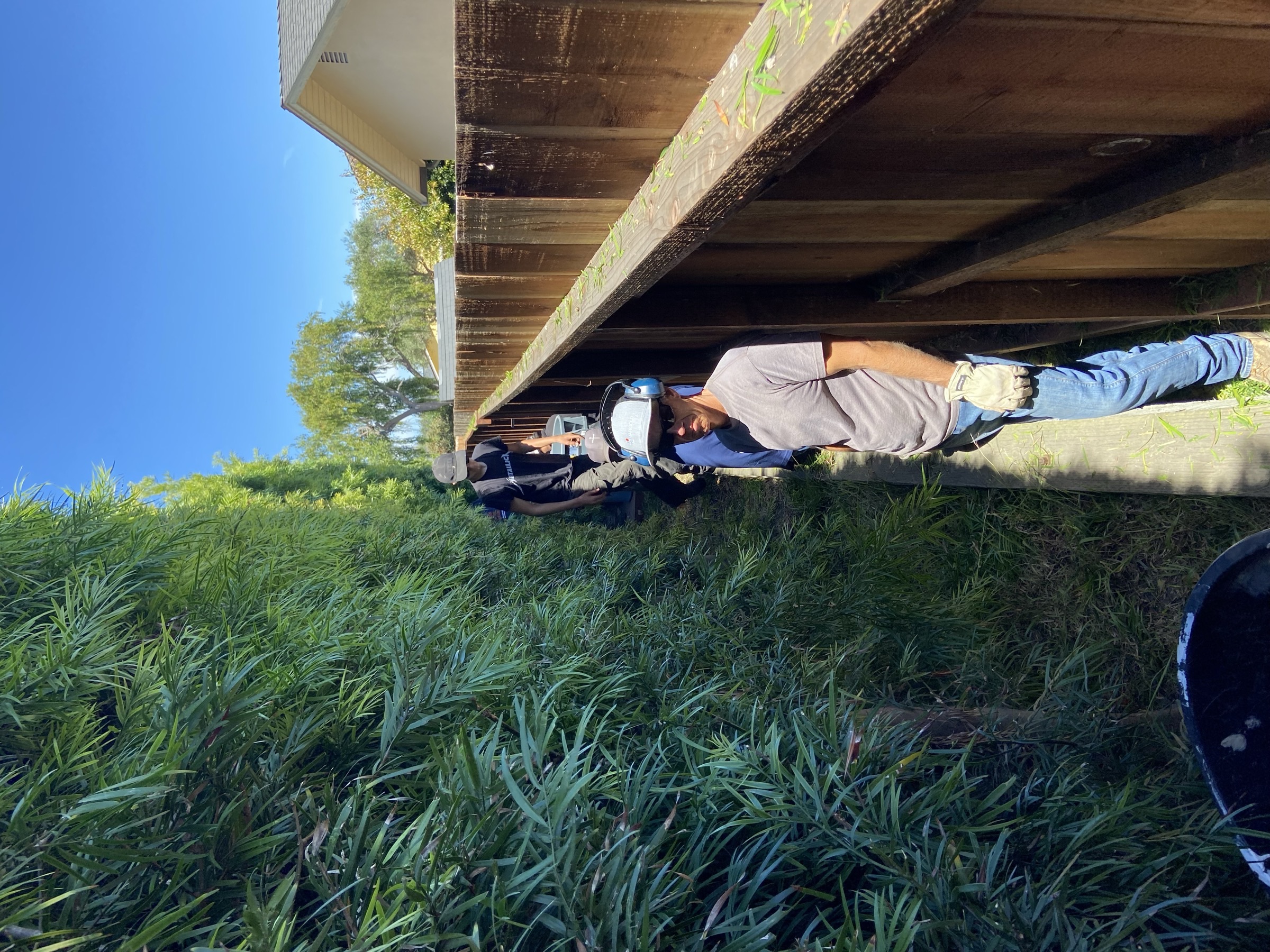 Mighty Men working along a wooden deck during a property service project